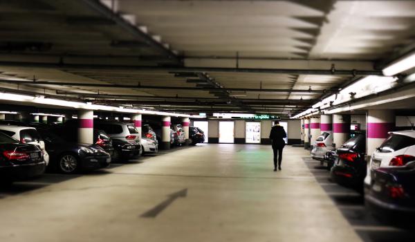 Man standing between cars in a residential parking garage