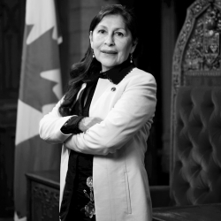 Senator Rosa Galvez stands in front of the speaker's chair in the Canadian Senate chamber.